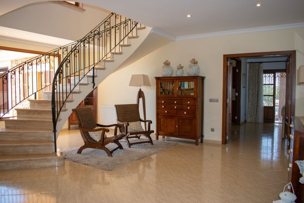 Eingangshalle, viel Licht Heller Flur mit Treppe, zwei Stühlen und einem Holzschrank.