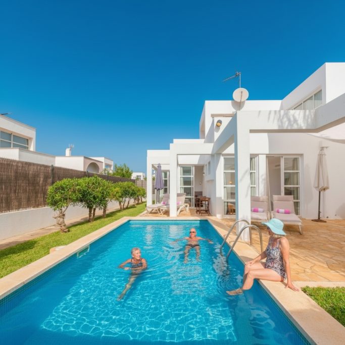 Pool, Garten, Bäume Moderne Villa mit Pool, umgeben von Rasen und Bäumen, an einem sonnigen Tag.