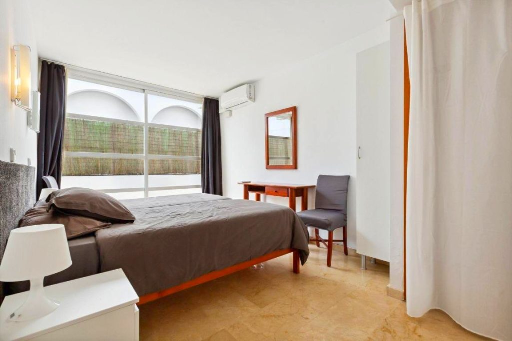 4. Schlafzimmer Helles Schlafzimmer mit einem Doppelbett, Schreibtisch und Stuhl. Aussicht auf einen Garten.