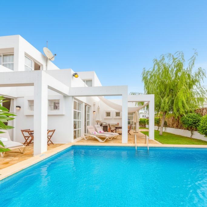 Pool, Grünanlagen, Terrassenmöbeln. Moderne Villa mit Pool, umgeben von Grünanlagen und Terrassenmöbeln.